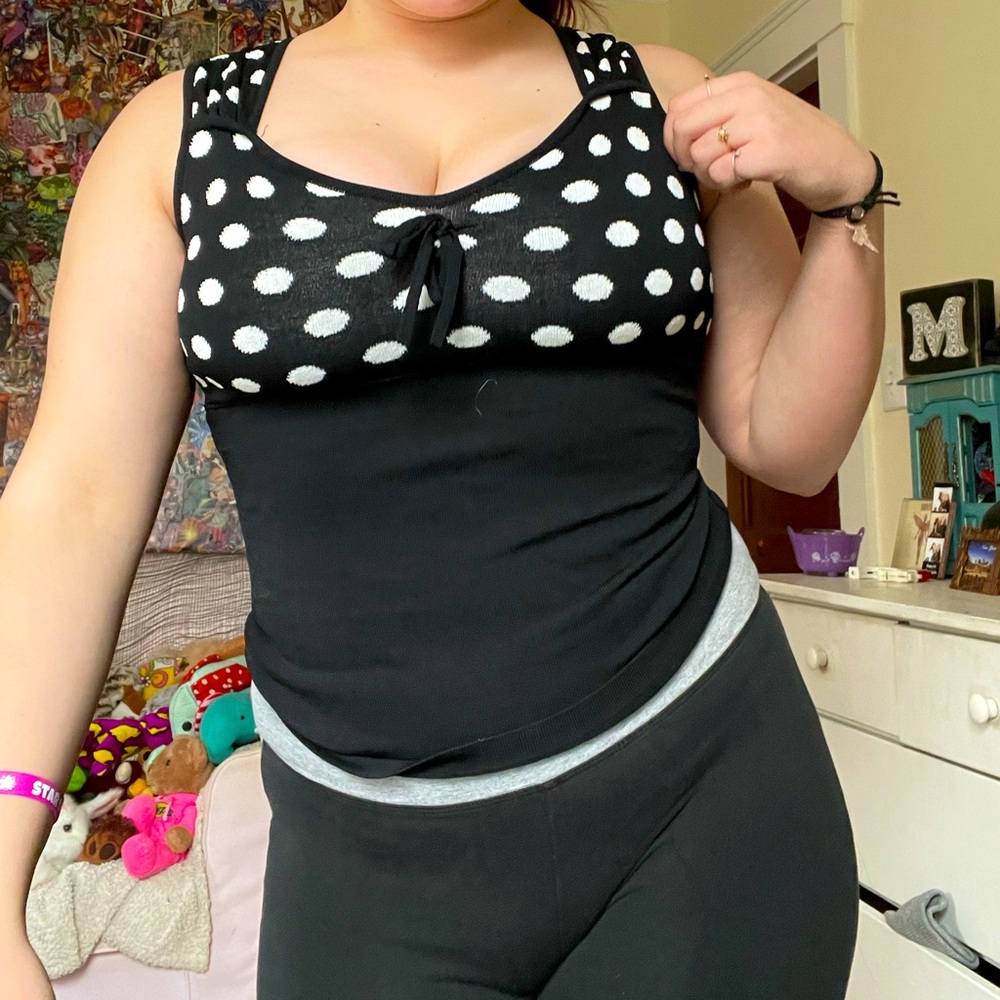 Black tank top, white polka dots on chest, 65% Rayon and 35% Nylon.